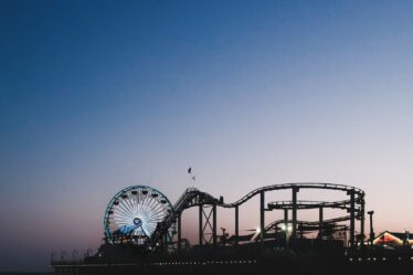 a roller coaster and a ferris wheel at dusk